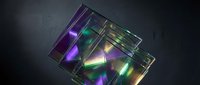Transparent glass prism blocks with vibrant neon light refraction in purple, green, and yellow hues on dark background. Isolated design element for tech, science, and creative projects.