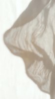Soft beige fabric flowing gracefully with elegant drapes and gentle shadows creating minimalist textile background for fashion and interior design projects.