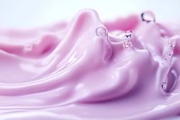 Smooth pink cosmetic cream texture with water droplets in macro photography, showing luxurious skincare product consistency and moisturizing properties.