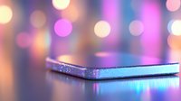 Glowing smartphone on reflective surface with soft pink and blue bokeh lights in background creating dreamy atmospheric mood for technology concept.