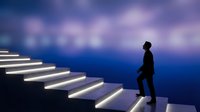 Silhouette of a businessman in formal attire standing before illuminated ascending stairs against a deep blue gradient background, symbolizing career growth and professional advancement.