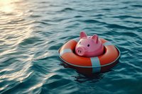 Pink piggy bank floating in life buoy on blue ocean water during sunset, financial safety and investment protection concept.