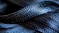 Luxurious dark hair strands with blue highlights flowing in elegant waves, showcasing natural texture and shine for beauty and haircare concepts.
