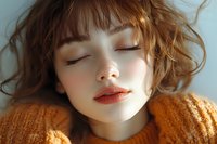 Young woman with closed eyes and red lips wearing orange knit sweater in soft natural light for beauty and fashion content.