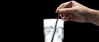 Hand holding a metal straw in a clear glass of water with ice, isolated on transparent background. Ready for stickers, print on demand, and t-shirt design use.