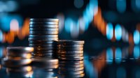 Stacked silver coins against blurred stock market chart background with orange and blue trading lines, representing financial investment and wealth growth concept.
