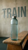 Chilled water bottle with condensation sitting on wooden bench against weathered wall with train text, fitness and hydration concept for gym, sports, and wellness marketing.