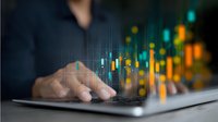 Professional trader analyzing financial market data on laptop with glowing candlestick charts and graphs in background, focus on hands typing on keyboard.