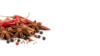 Aromatic spices collection with star anise, red chili peppers, black peppercorns and coriander seeds isolated on white background for culinary designs.