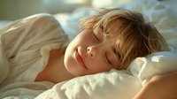 Peaceful sleeping child with blonde hair resting on white pillows in morning sunlight, perfect for articles about healthy sleep habits, childhood wellness, and parenting blogs.