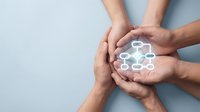 Multiple diverse hands joining together holding glowing network connection icon, representing teamwork, collaboration, unity, and shared digital communication for business partnerships.