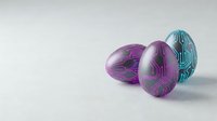 Three colorful marbled Easter eggs with swirled patterns in purple and teal colors arranged on white background for holiday decorations and spring celebrations.