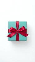 Turquoise gift box with red satin ribbon bow on white background, isolated for holiday, celebration, and retail design use.