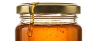 Golden honey flows from jar lid, showcasing pure, organic sweetness. Use for food, wellness, and culinary marketing materials.