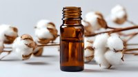 Amber essential oil bottle with cotton flowers, showcasing natural skincare ingredients for aromatherapy, wellness, and organic beauty products.