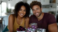 Young diverse couple sharing healthy breakfast with fresh berries and smoothie bowl in modern bright kitchen, expressing joy and wellness lifestyle.