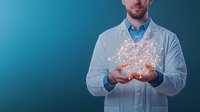Caucasian male doctor in white coat holding glowing network hologram visualization above hands against blue background, representing medical technology innovation.