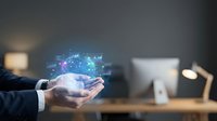 Businessman holding glowing digital brain with financial charts, representing AI-powered data analytics and future technology innovation.