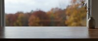 Wooden windowsill with autumn foliage view, ideal for product placement, seasonal marketing, and home decor design projects.