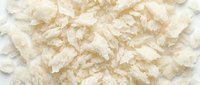 Dried coconut flakes scattered on white background, ready for food packaging, culinary design, baking projects, and ingredient marketing materials.