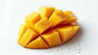 Fresh ripe mango sliced and diced with water droplets on white background. Tropical fruit cut ready to eat for healthy nutrition and cooking.