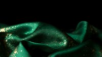 Shimmering emerald green mermaid tail with sparkling scales and flowing fins against dark background for fantasy and mythical creature designs.