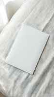 Blank white card on natural linen fabric with soft shadows creating minimalist mockup scene for branding and stationery design projects.