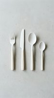 White plastic cutlery set arranged on neutral surface, featuring fork, knife, and spoons for dining, catering, and tableware design projects.