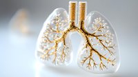 Anatomical glass lungs with golden bronchial tree structure illuminated on light background showing detailed respiratory system branching pattern for medical concept.