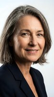 Mature woman with gray hair wearing dark blazer, smiling at camera against white background. Corporate headshot for business, professional profiles.