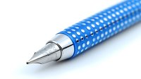 Fountain pen with blue polka dot pattern on white background, close-up view of metal nib tip. Isolated stationery item for design and creativity projects.