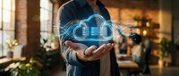 Businessman holding glowing cloud computing hologram with data streams, digital technology concept in modern office workspace.
