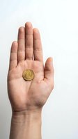 Open palm holding golden coin on white background for financial concepts and business presentations.