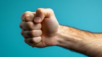 Male Caucasian hand clenched in tight fist showing anger and strength against turquoise background, demonstrating power, aggression and determination.