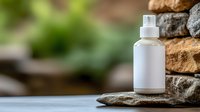 White frosted glass spray bottle with pump dispenser on natural stone surface outdoors for skincare cosmetics and wellness products.
