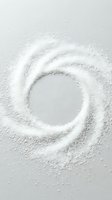 White granulated powder arranged in a swirling spiral pattern on neutral background, creating circular vortex design with empty center space for text overlay or product placement.