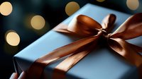 Elegant gift box wrapped in matte blue paper with luxurious copper satin ribbon bow against dark background with soft golden bokeh lights for special occasions.