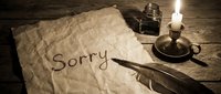 Vintage apology letter with the word Sorry written on aged parchment, quill pen, ink bottle, and candlelight on rustic wooden table.