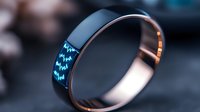 Modern rose gold ring with glowing blue digital display showing stock market data, combining luxury jewelry design with smart technology for financial tracking.