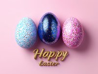 Festive glitter-covered Easter eggs in blue, navy, and pink arranged in row with golden Happy Easter text on pink background. Modern holiday celebration concept.
