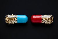 Two colorful pharmaceutical capsules filled with small spherical pellets on black background for medical and healthcare concepts.