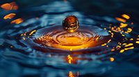 Water drop splash creating golden crown effect with blue background and orange light reflections, macro photography capturing liquid surface tension and ripples.