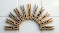 Wooden clothespins arranged in semicircle pattern on white background for laundry, crafts and home organization projects.