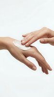 Two hands applying white moisturizing cream or lotion on skin against neutral background. Skincare, cosmetics, and beauty product application concept for dermatology and wellness.