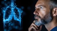 Caucasian mature man with gray beard contemplating glowing blue holographic lung scan visualization on dark background, medical technology concept.