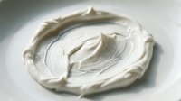 Creamy white whipped dairy topping swirled on plate, ready for dessert garnish, baking projects, food styling, and culinary presentations.