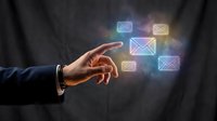 Hand of a professional male in business attire pointing at glowing email icons, representing digital communication, messaging services, and online contact management for business applications.