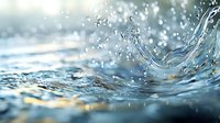 Macro shot of crystal clear water splash with droplets frozen in motion against blurred blue background, creating dynamic movement and natural abstract pattern.