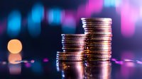 Stacked silver coins against blurred pink and blue bokeh background showing financial growth concept with dramatic lighting and reflective surface.