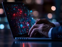 Hands typing on laptop keyboard with glowing red and blue digital network visualization on screen, dark atmosphere with bokeh lights in background.